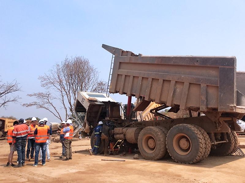 Dans la base des utilisateurs de l'entreprise minière à Katanga, le représentant en chef dirigant l'équipe du service après-vente pour guider et communiquer avec les clients sur la maintenance et l'utilisation des camions minières.