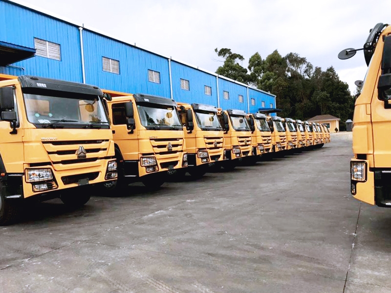 Le camion à benne HOWO-7 a été livré sur le site du client kenyan, et les véhicules ont été soigneusement arrangés, en attente de livraison pour être mis dans la construction technique du Kenya.